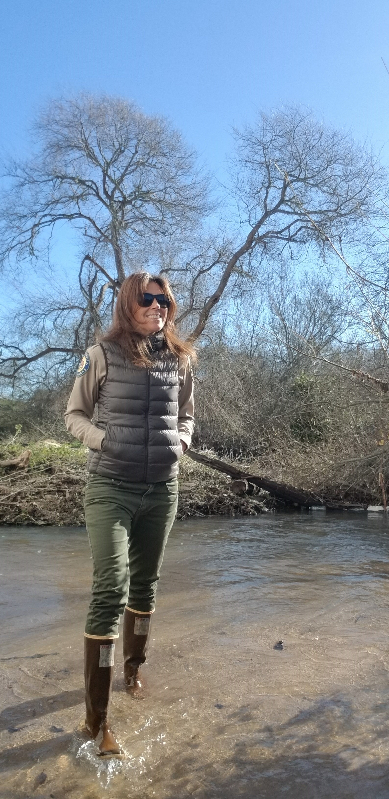 Guide Marika walking down flooded dirt road in galoshes
